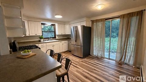 A kitchen with a table and chairs in front of a window.