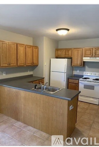 A kitchen with wooden cabinets and a white fridge.
