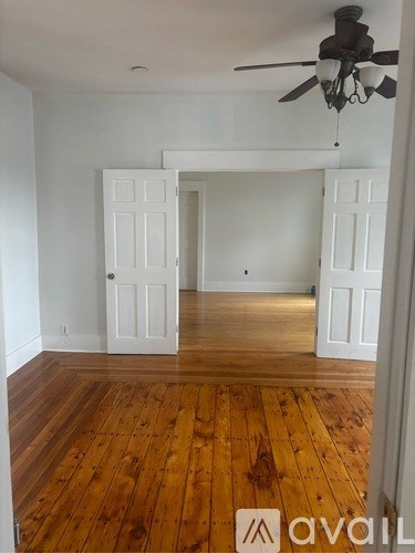 A room with wooden floors and a ceiling fan.