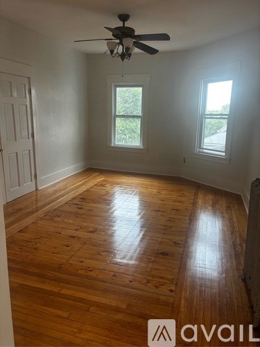 A room with wooden floors and a ceiling fan.
