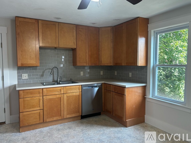 A kitchen with wooden cabinets and a window.
