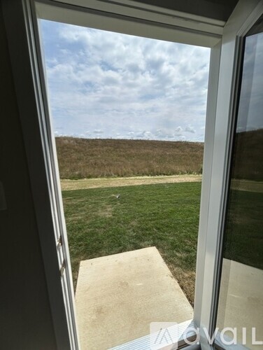 A view from a window looking out to a grassy field.
