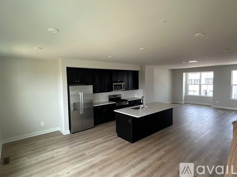A kitchen with a refrigerator, sink, and cabinets.