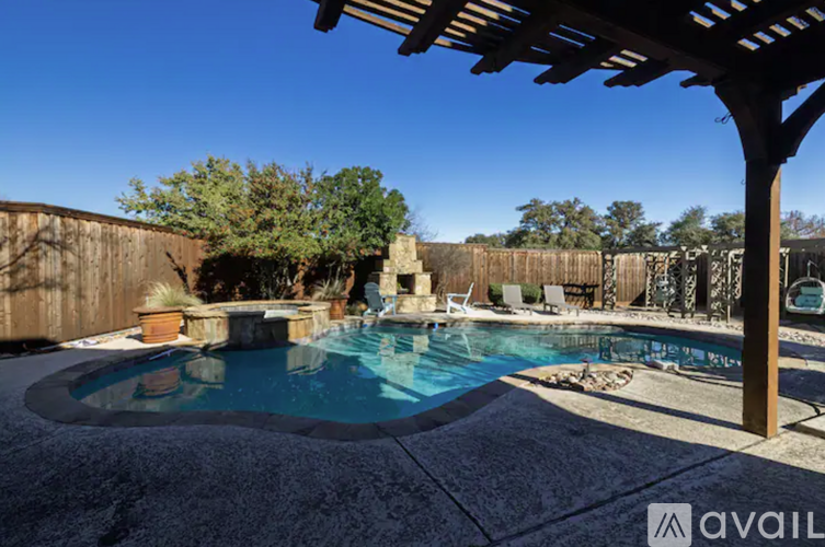 A pool with a hot tub and a pergola.