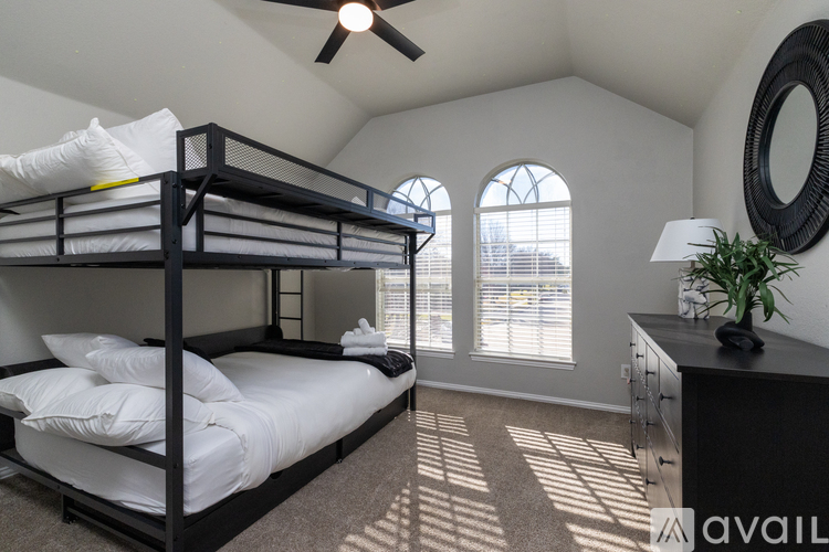 A bedroom with a bunk bed and a ceiling fan.