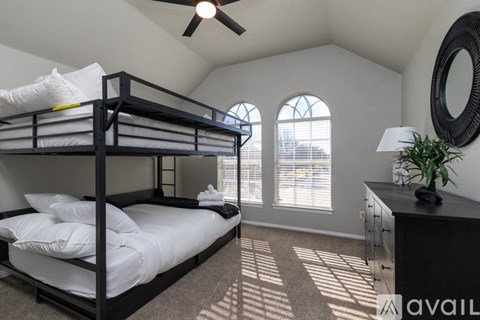 A bedroom with a bunk bed and a ceiling fan.