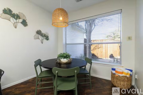 A dining room with a table and chairs.