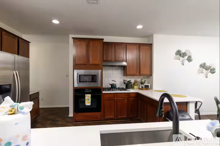 A kitchen with brown cabinets and a white counter.