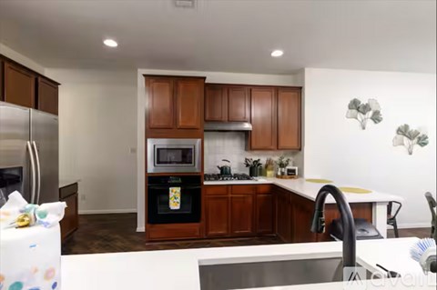 A kitchen with brown cabinets and a white counter.