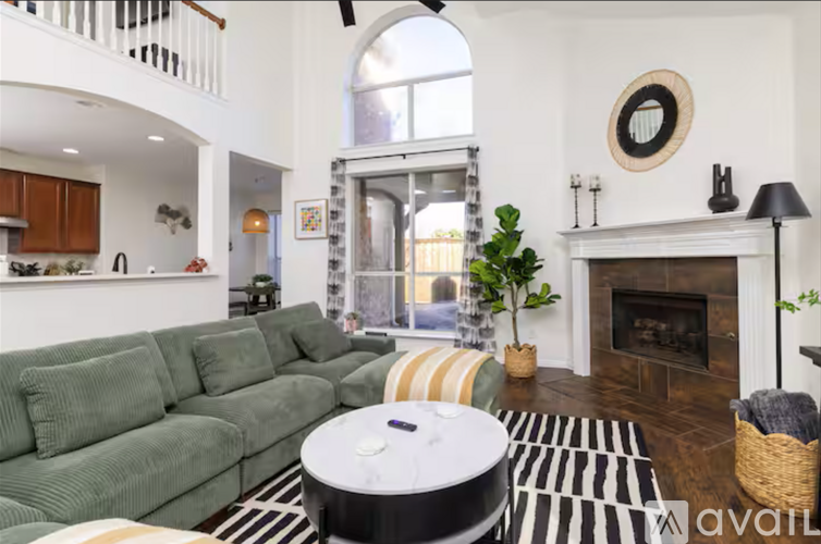 A living room with a green couch and a fireplace.