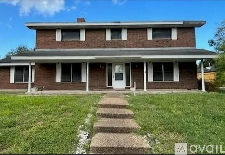 A two-story brick house with a front porch.