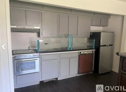 A kitchen with white cabinets and a stainless steel refrigerator.