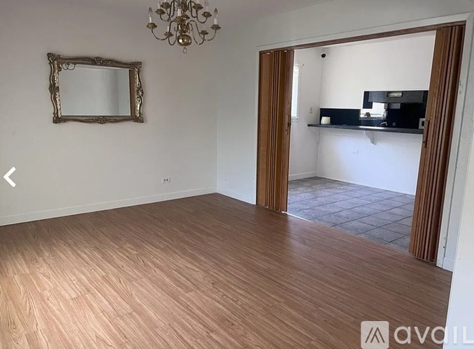 A room with wooden flooring and a chandelier.