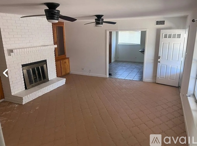 A living room with a fireplace and a fan.