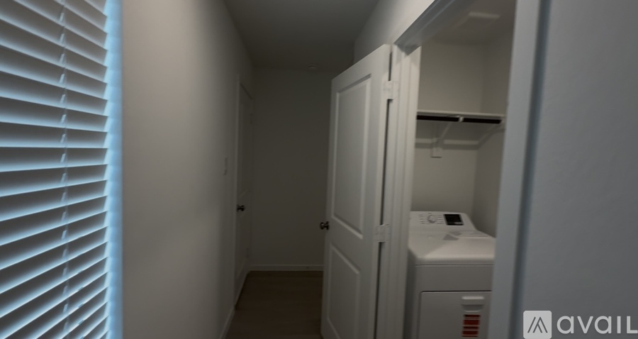 A small, white, enclosed space with a door and a window with blinds.