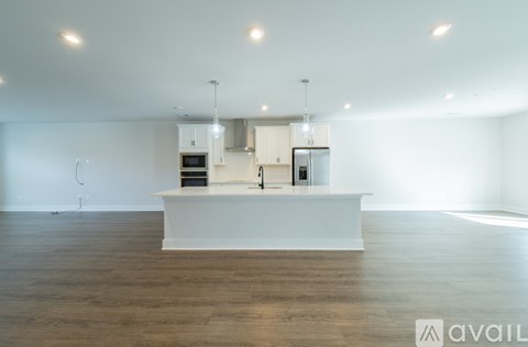 A kitchen with white cabinets and appliances is available for rent.