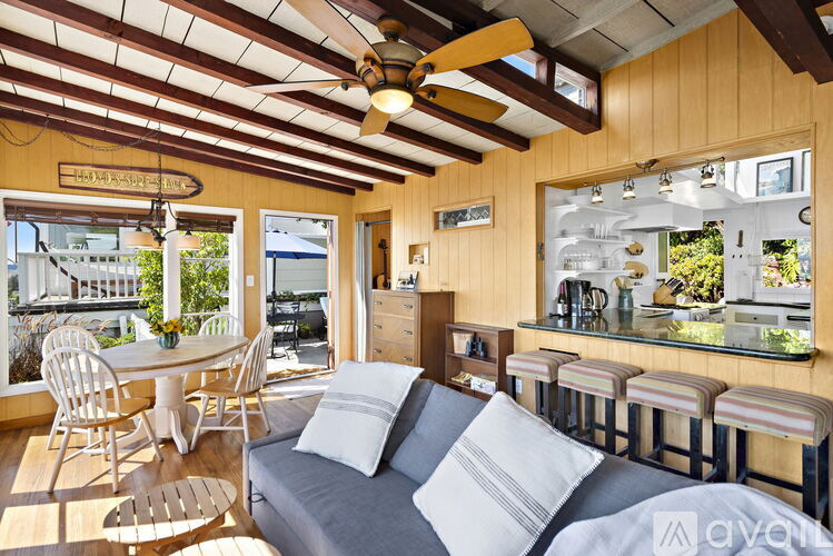 A living room with a couch, chairs, and a ceiling fan.