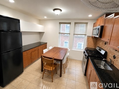 A kitchen with black appliances and wooden cabinets.