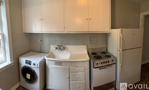 A small kitchen with a washing machine, sink, stove, and refrigerator.