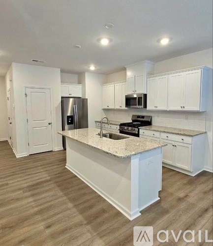 A kitchen with white cabinets and a granite countertop.