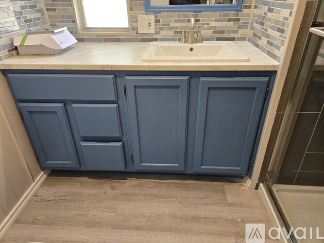 A bathroom with a sink and cabinets.