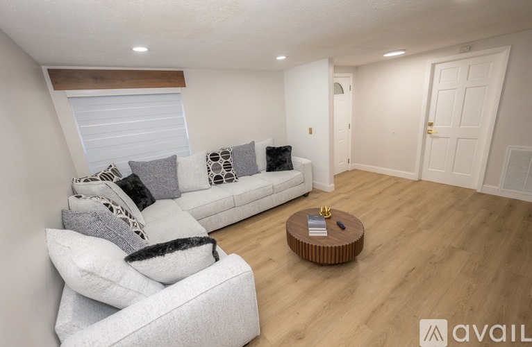 A living room with a white couch and a wooden coffee table.