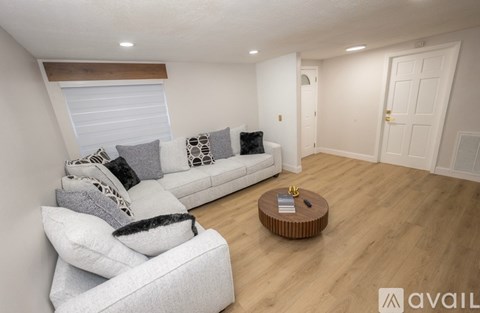 A living room with a white couch and a wooden coffee table.