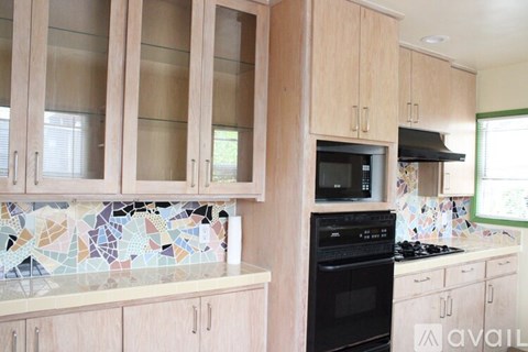 A kitchen with wooden cabinets and a black oven.