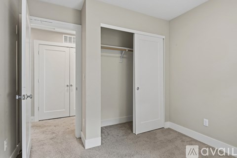 A bedroom with a white door and a white closet.