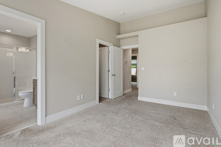 A spacious room with a carpeted floor and a doorway leading to another room.