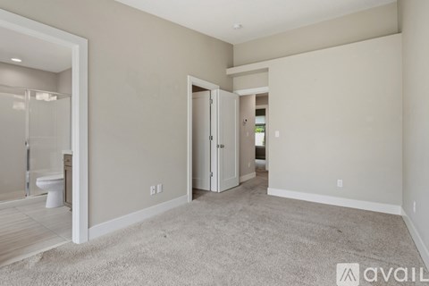 A spacious room with a carpeted floor and a doorway leading to another room.