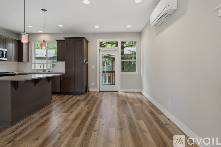 A kitchen with wooden floors and a white wall.