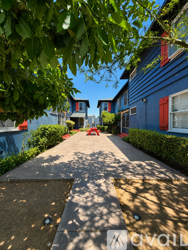 A blue building with a red door and windows.