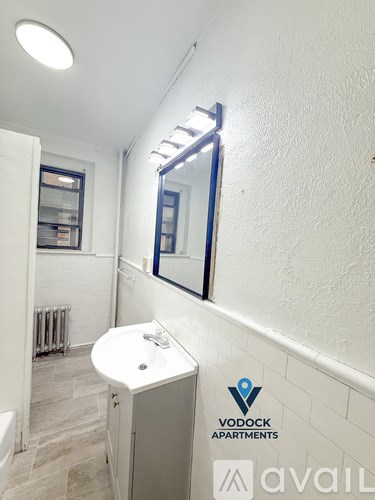 A bathroom with a white sink and a mirror on the wall.