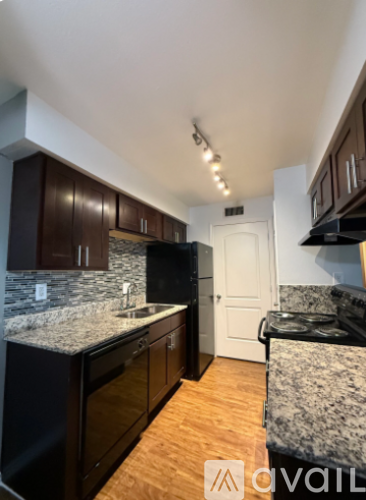 A kitchen with dark wood cabinets and granite countertops.
