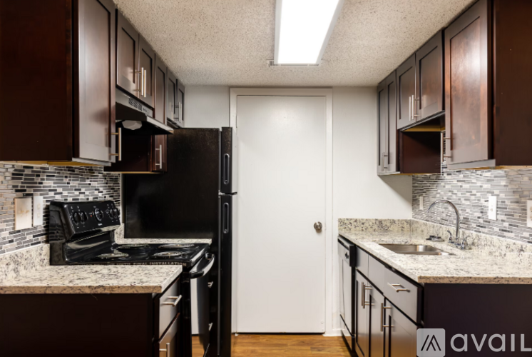 A kitchen with brown cabinets and a black stove top oven.