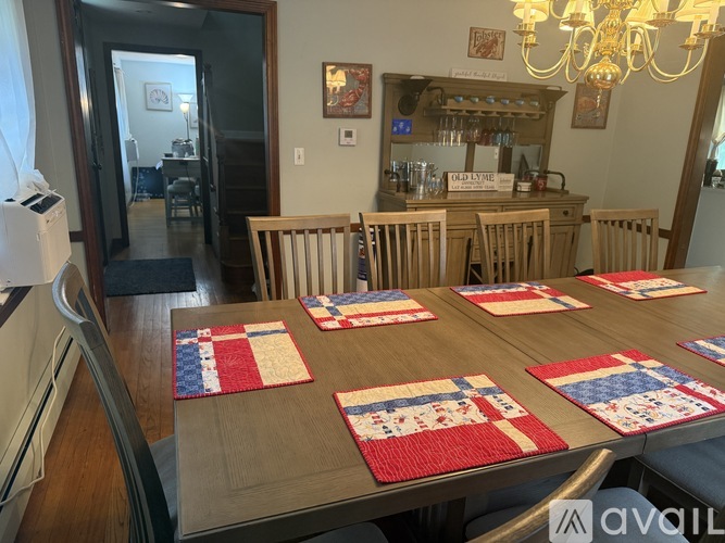 A dining room with a wooden table and chairs.