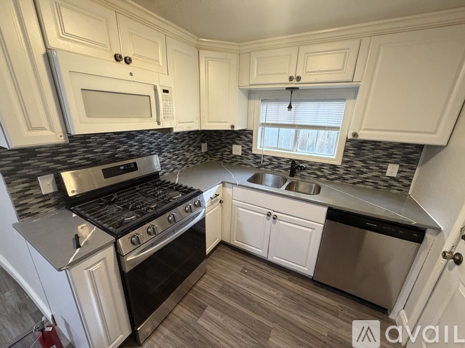 A kitchen with white cabinets and a black stove top oven.