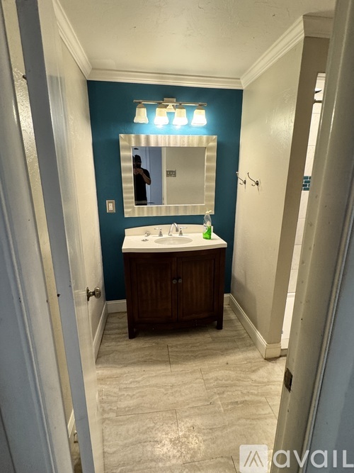 A bathroom with a blue wall and a white sink.
