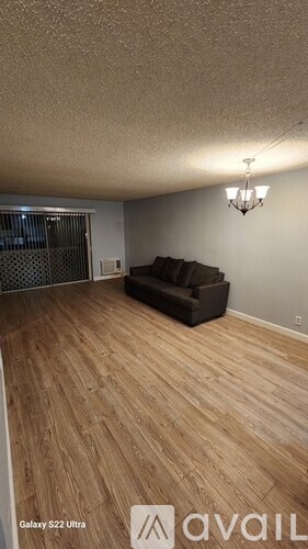 A living room with a couch and a chandelier.