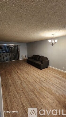 A living room with a couch and a chandelier.