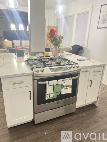 A modern kitchen with a stove top oven and white cabinets.