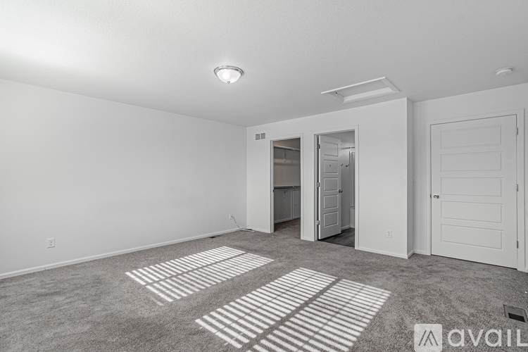 A spacious room with a carpeted floor and white walls.