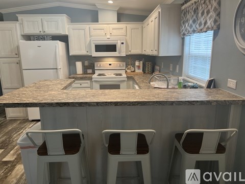 A kitchen with white cabinets and a granite countertop.