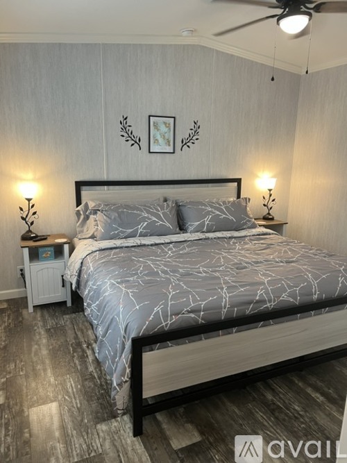 A bedroom with a large bed and a ceiling fan.