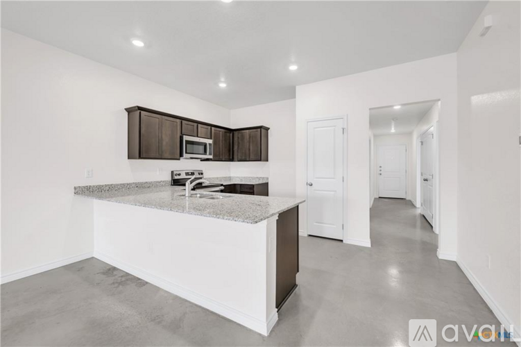 A kitchen with a granite countertop and a microwave above it.