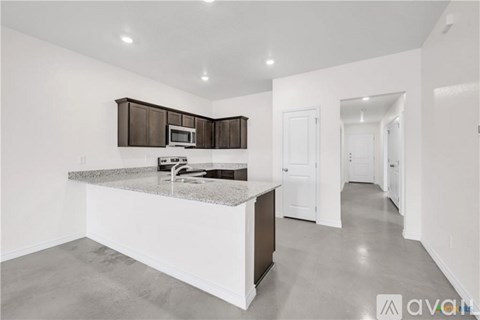 A kitchen with a granite countertop and a microwave above it.