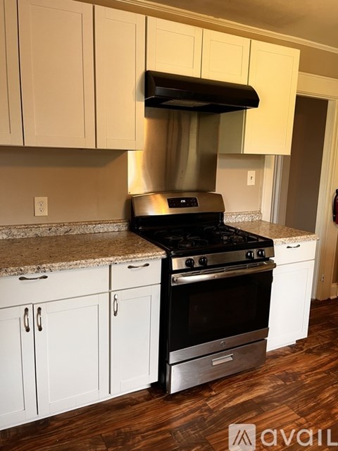 A kitchen with a black stove top oven and white cabinets.