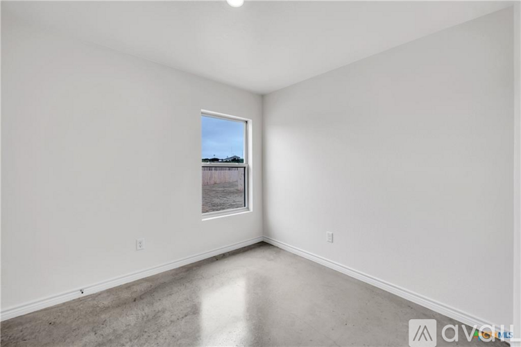 A room with a window showing a view of a building outside.