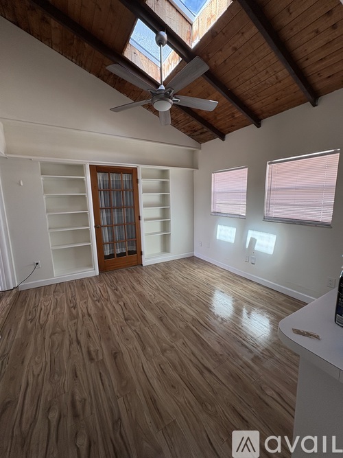 A room with wooden floors and a ceiling fan.